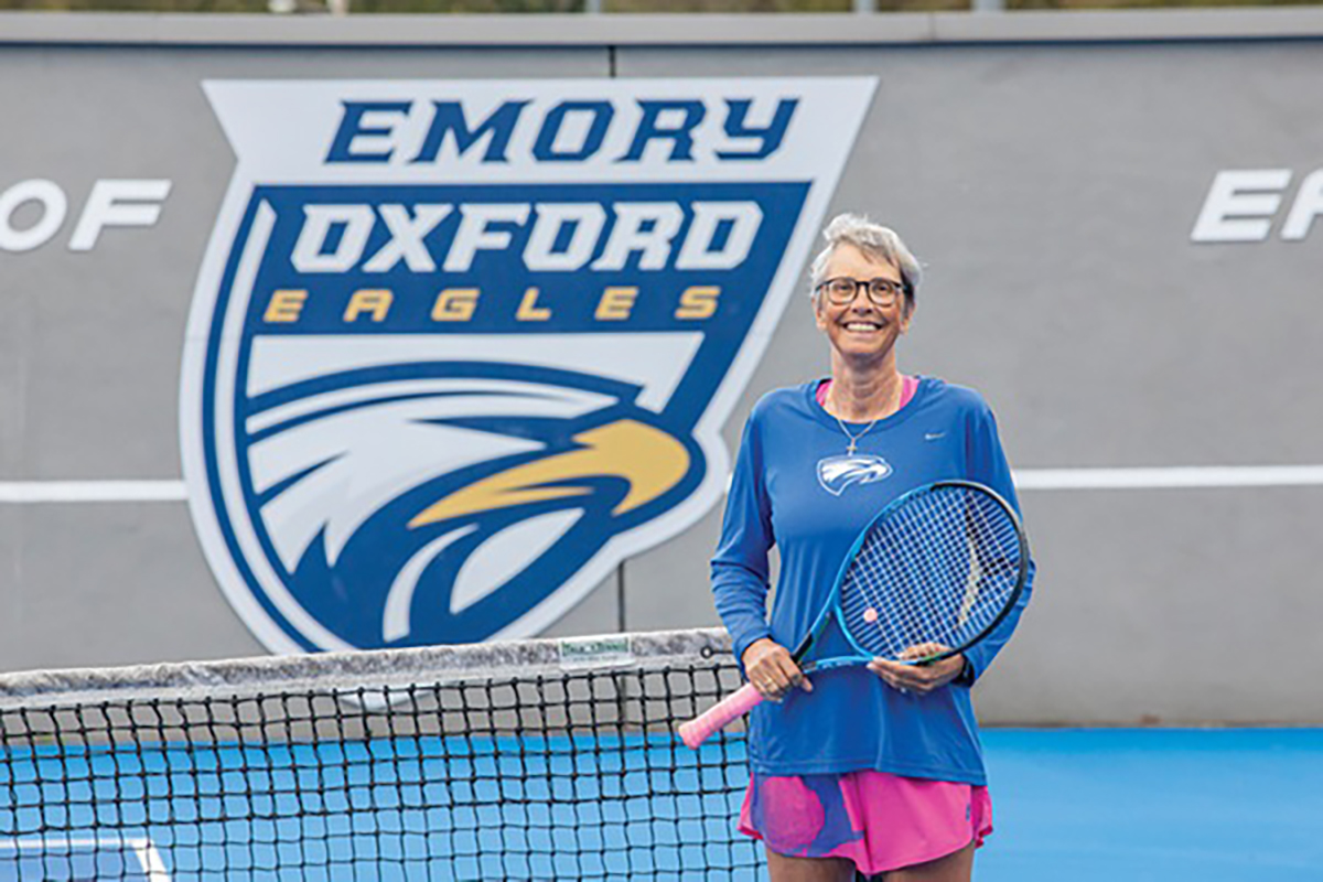 Coach Pernilla Hardin smiling, holding a tennis racket on the court.